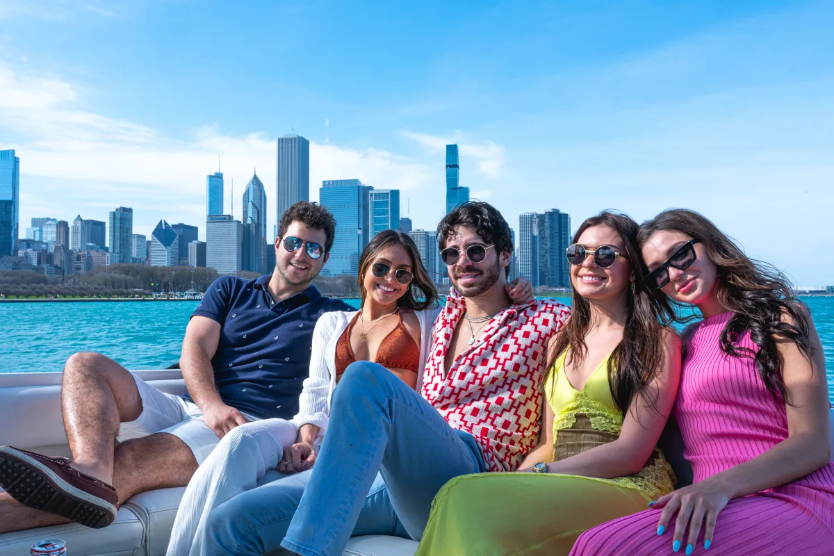 Group of friends with their arms around each other on a boat rental in Chicago during Memorial Day Weekend