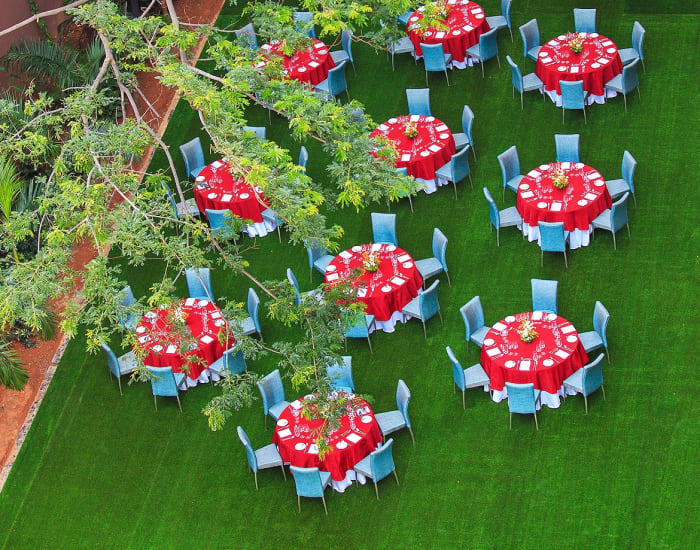 Renaissance Bengaluru Race Course Hotel wedding banquet dining setup with floral centrepieces — Panigrahana