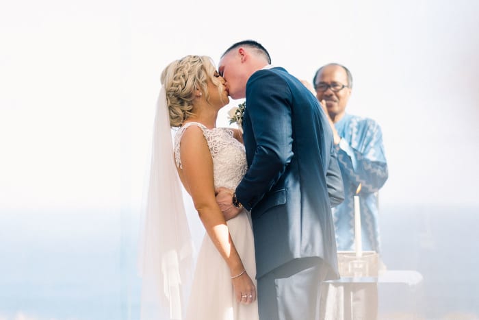 Tirtha Uluwatu Bali garden ceremony space decorated with white flowers and floral arch — Panigrahana