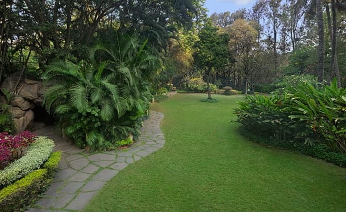 The Oberoi Bengaluru lush award-winning tropical garden lawn decorated for outdoor wedding ceremony — Panigrahana