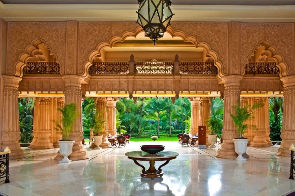 Leela Palace Bangalore indoor grand ballroom reception with floral centrepieces — Panigrahana
