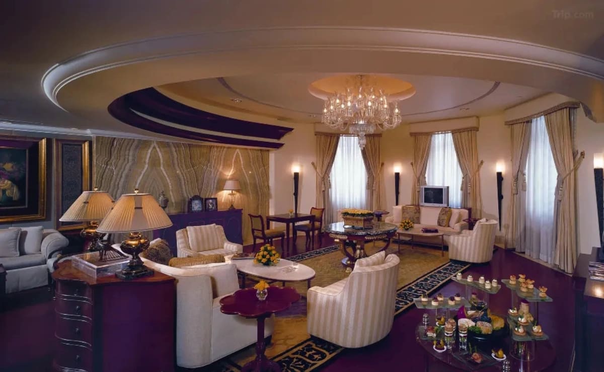 Leela Palace Bangalore indoor grand ballroom reception with floral centrepieces — Panigrahana