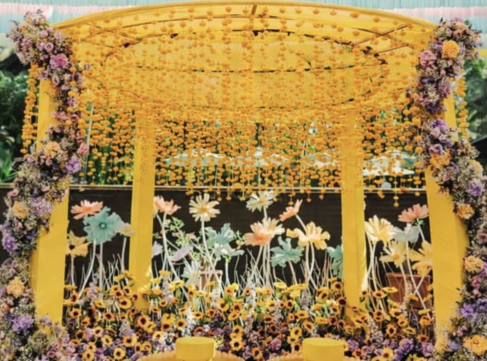 Vibrant yellow sunflower and marigold haldi ceremony mandap by Panigrahana
