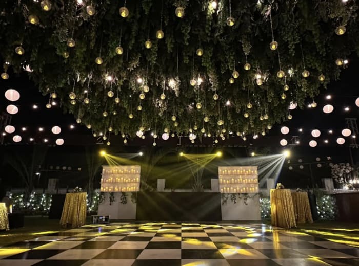 Outdoor wedding sangeet dance floor with checkered tiles and greenery