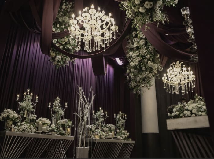 Luxury wedding reception with crystal chandeliers and cascading white florals