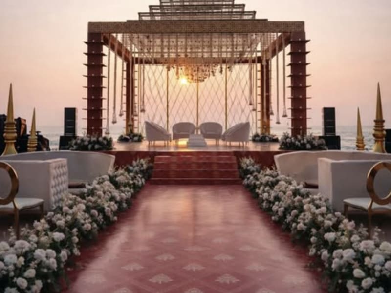 Sunset mandap overlooking the ocean with white floral aisle — beachfront wedding Panigrahana Goa