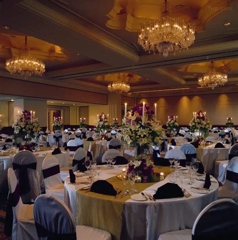 Leela Palace Bengaluru wedding reception hall with chandelier and floral stage decor — Panigrahana