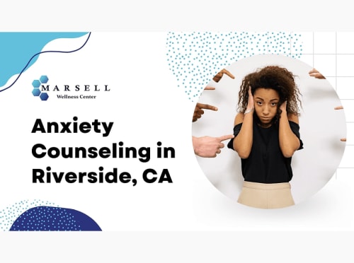 An anxious woman has her hands pressed against the sides of her head.