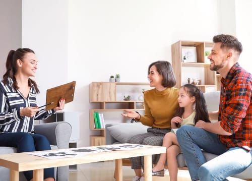 mom and dad sit with their young daughter in a family therapy session