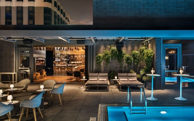 The pool at the Viceroy Hotel illuminated by lights during nighttime.