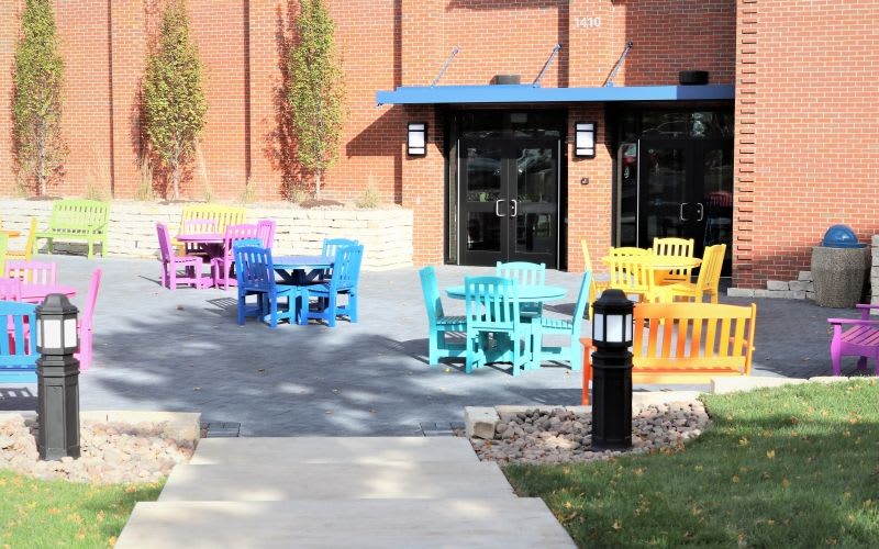 Colorful chairs and benches outside the building.