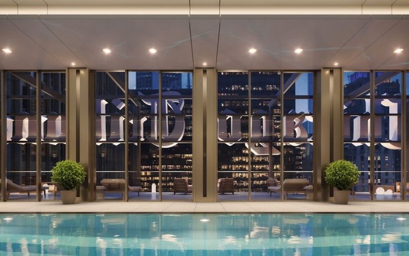 The swimming pool at the Tribune Tower with lighting illuminating it at night.