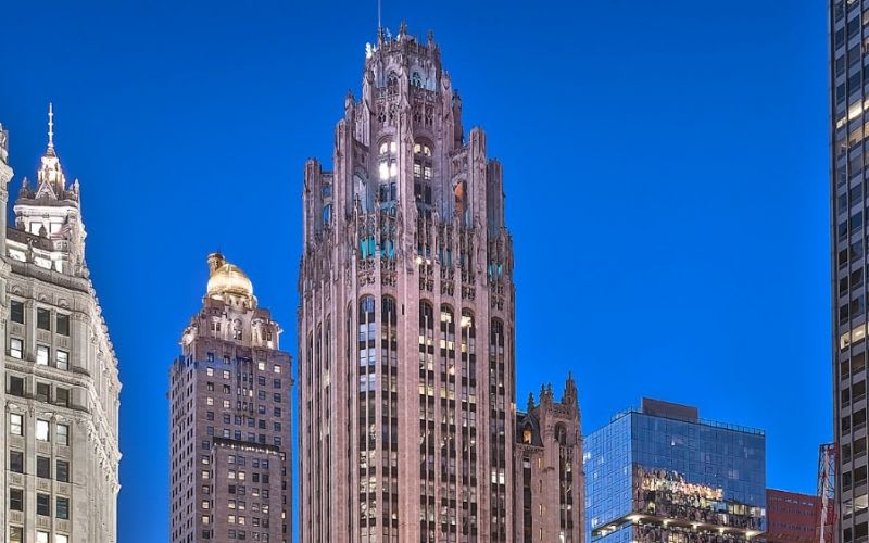 The exterior of the Tribune Tower illuminated late at night.