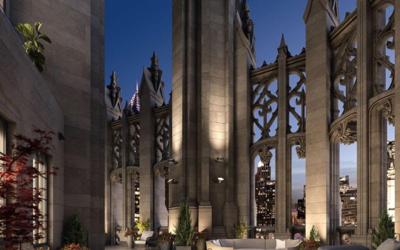 The rooftop terrace at the Tribune Tower with light fixtures illuminating the beautiful, gothic architecture at night.