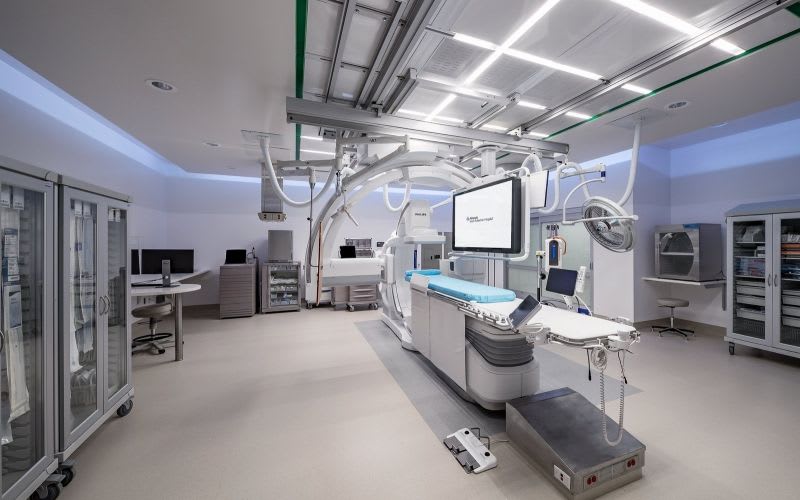 Operating room with long, linear lights, an operating table and equipment around it.