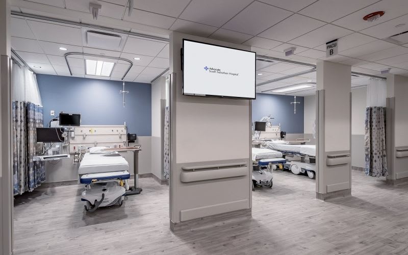 PACU rooms within the hospital showing multiple beds and lights over each one.