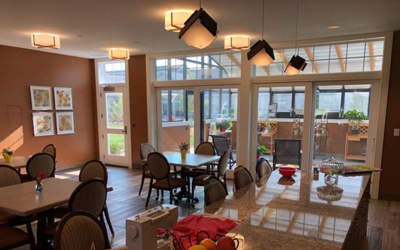 The bistro dining area with a couple chairs, tables and ceiling and pendant lighting.