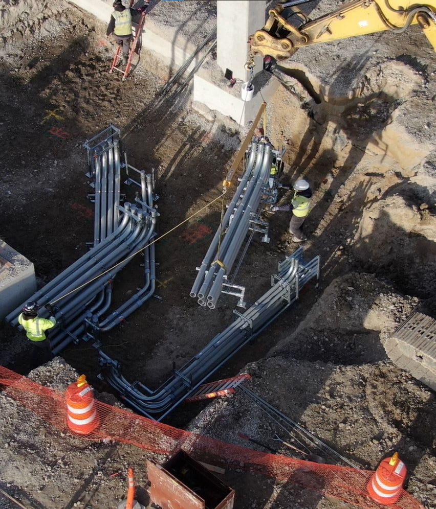 Electrical construction site workers placing duct banks underground