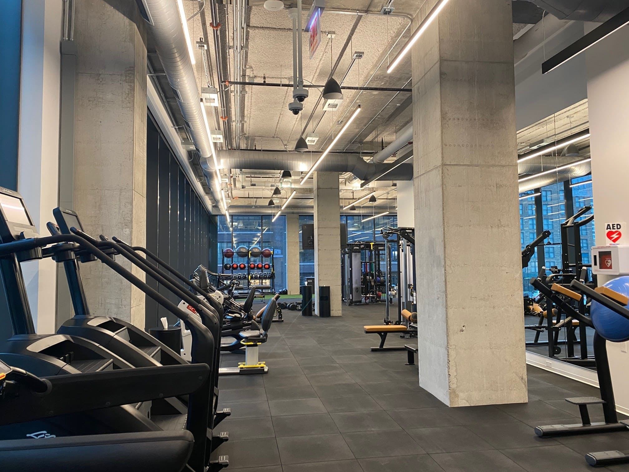 The fitness room with a couple treadmills and various exercise machines in the background.