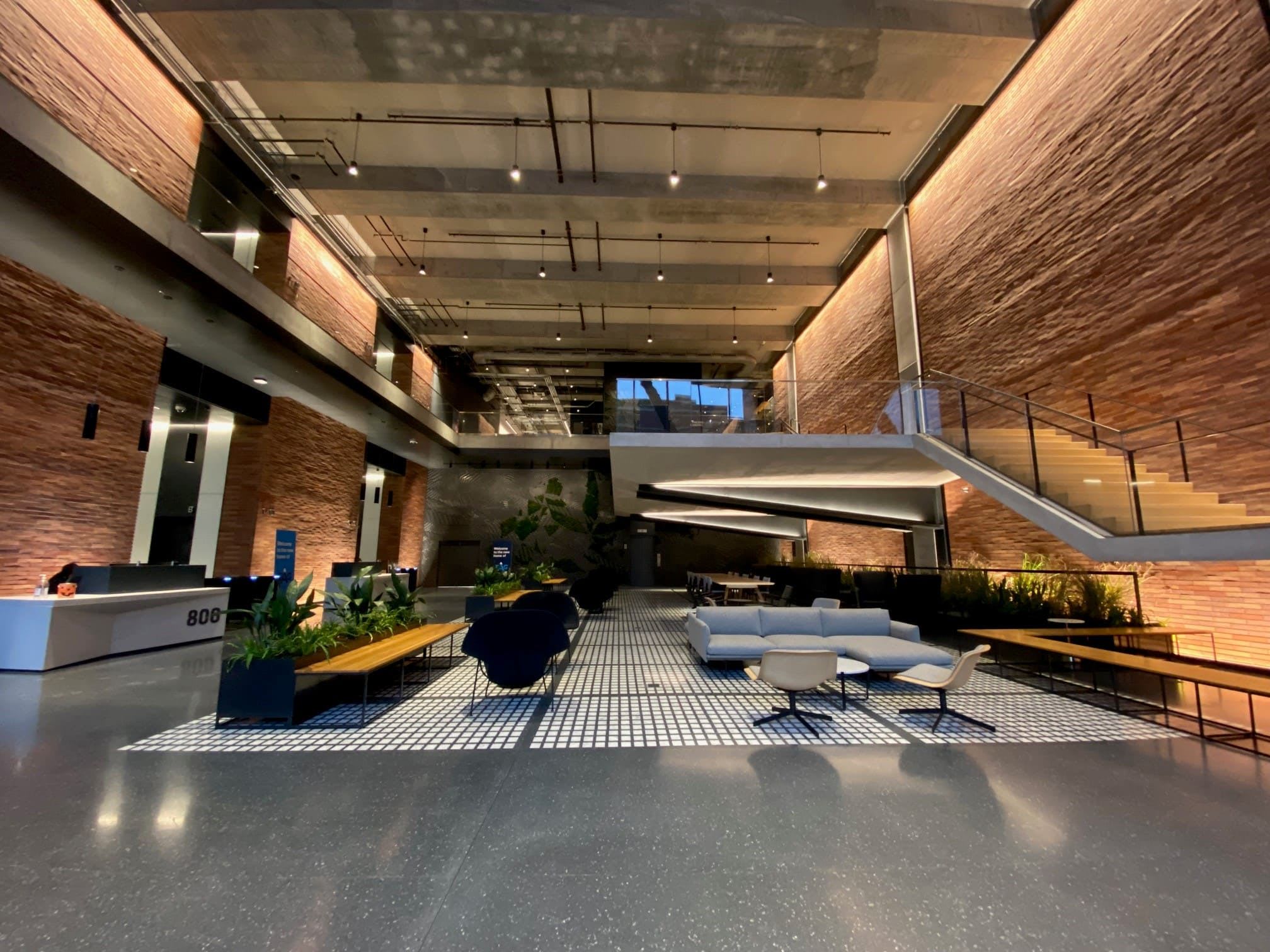 Different view of the lobby showing hanging pendant lights and staircase lights illuminating it.