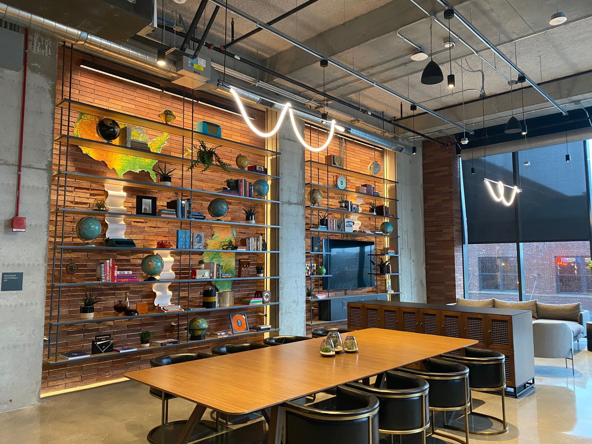 Social space inside 800 W. Fulton with a modern, industrial bookshelf and items and books on them.