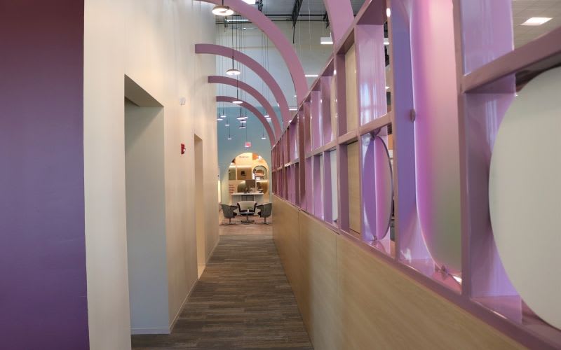 Long hallway adorned with a purple architectural fixture.