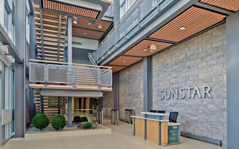 Lobby at Sunstar showcasing a long wooden staircase and some decorative plants inside.