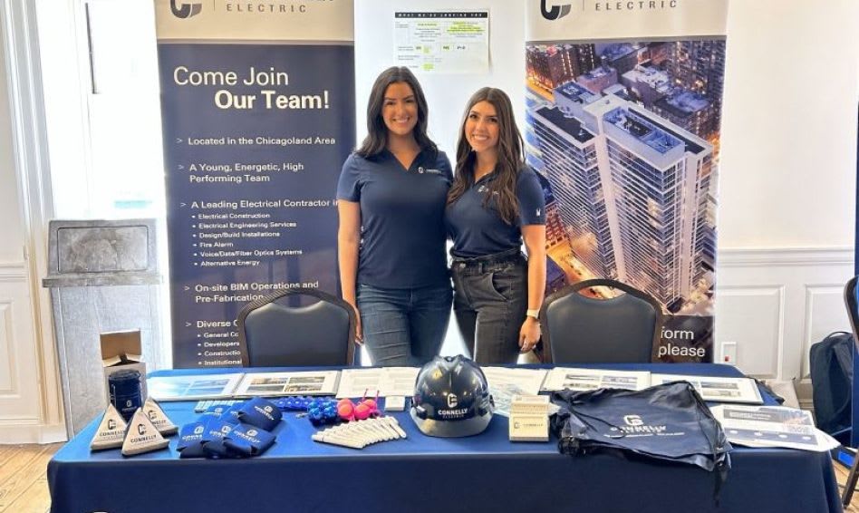 Two Connelly employees at a career fair booth next to a Connelly-branded sign that says "Come Join Our Team".