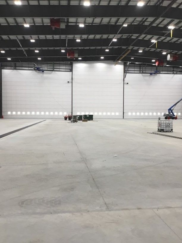 Another view of the inside of the hangar, showing many lights inside of it.