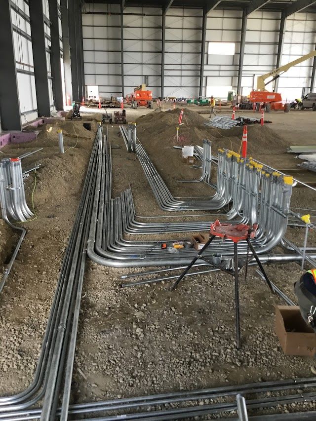 Construction and electrical work below the floor of the hangar.