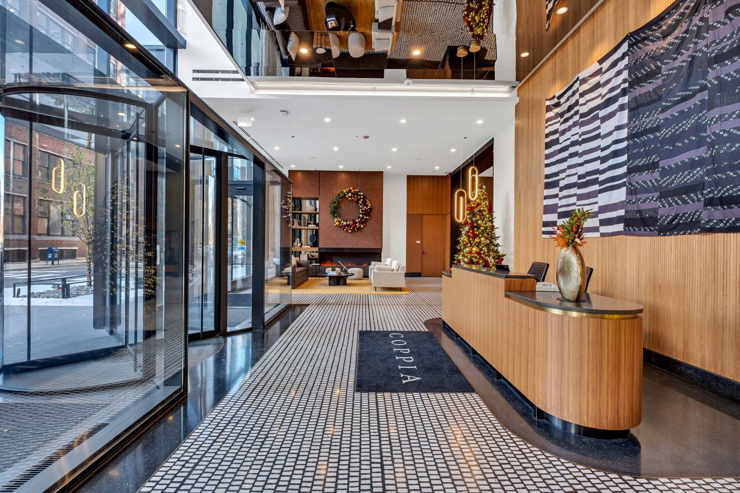 Lobby inside 1101 W. Van Buren, decorated with wood panels, Christmas trees and modern pendant lights. 