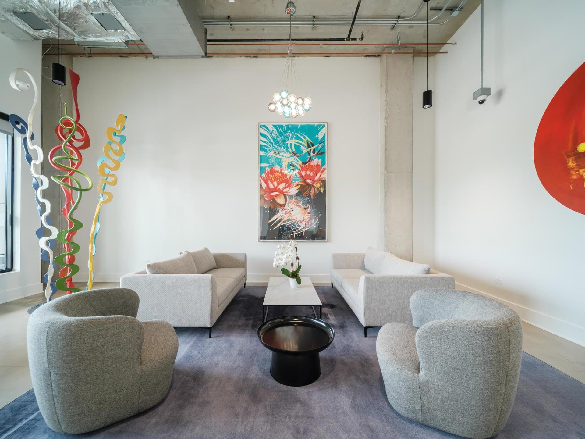 A social space with comfortable couches and seating areas and art work displayed.