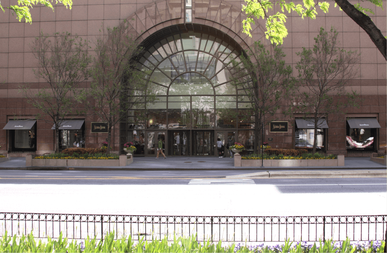 The exterior facade of Neiman Marcus showing a large rounded glass entrance.