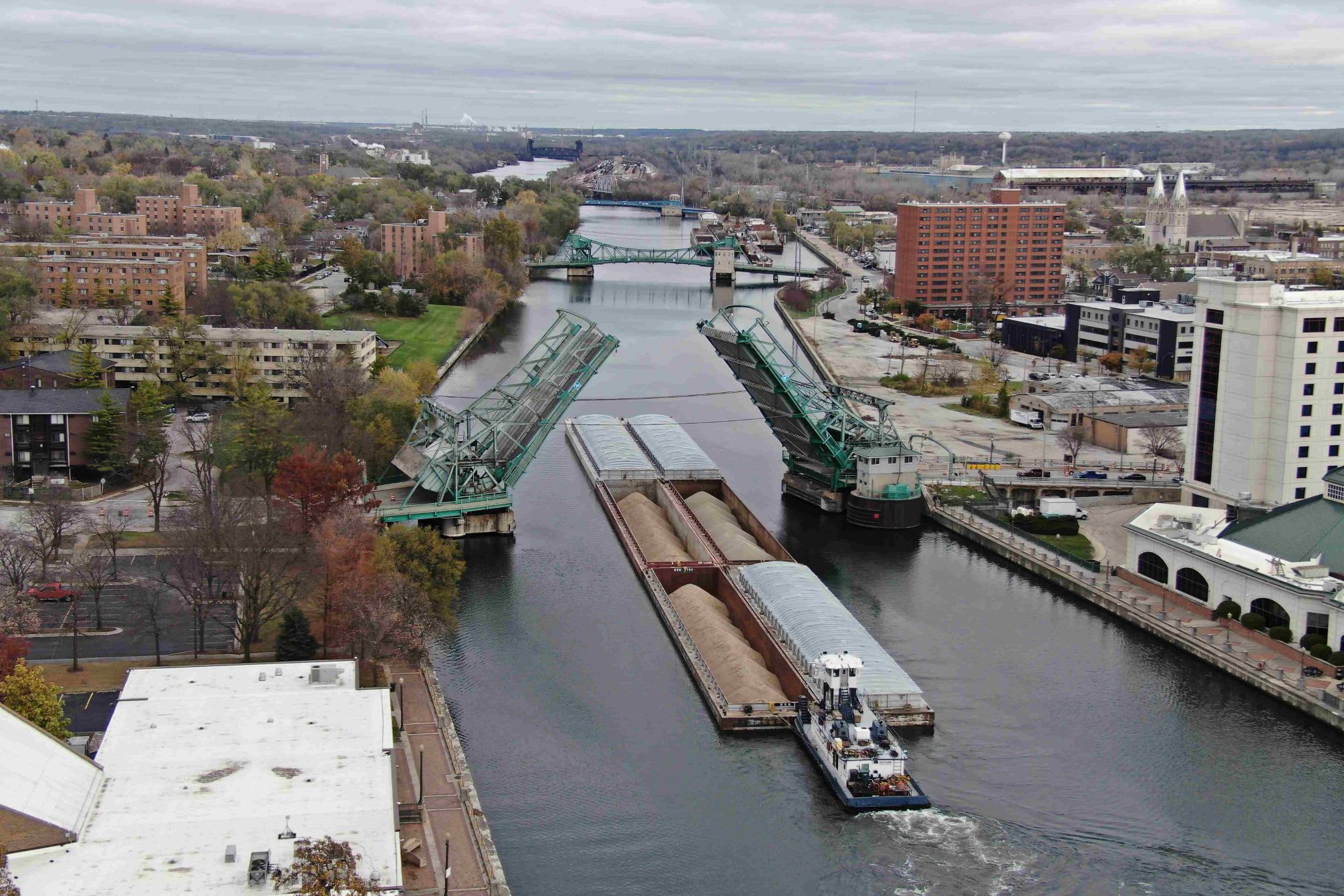 Vessel transporting sand and other materials passing the bridge after it has pivoted upwards.