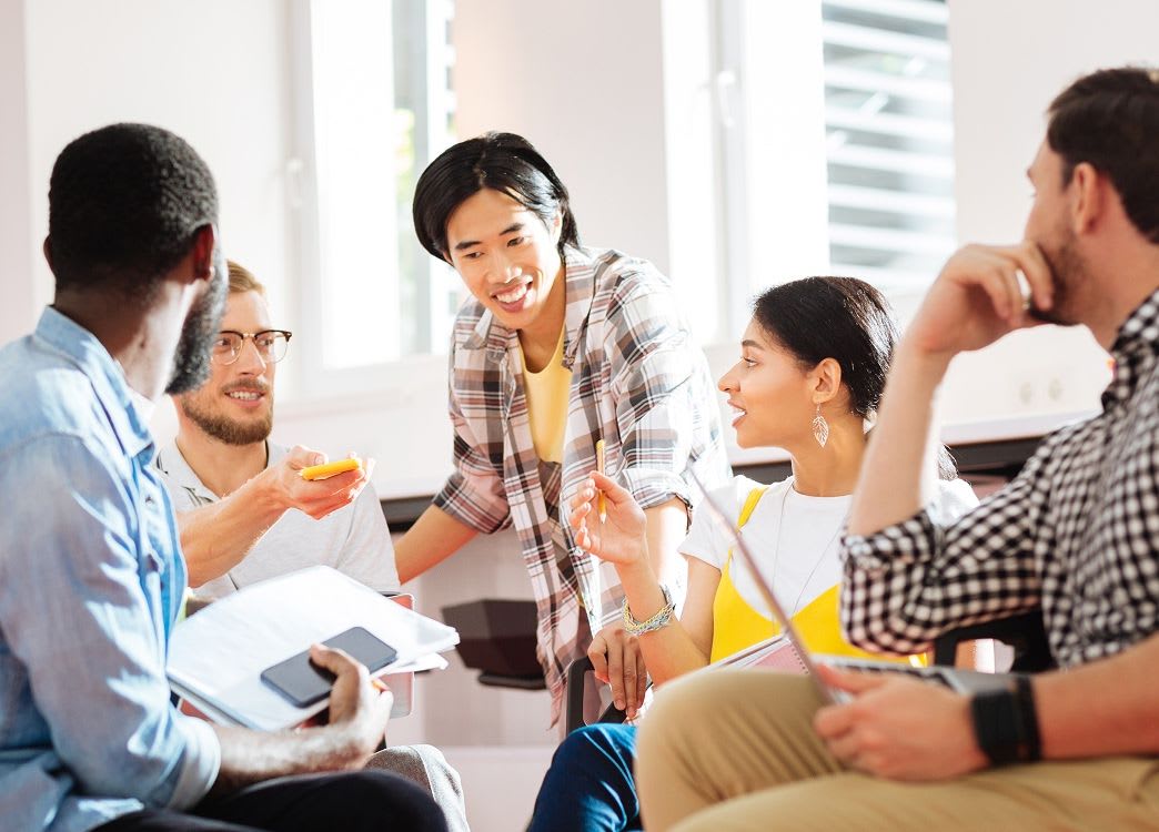 group of five colleagues brainstorm together in a circle