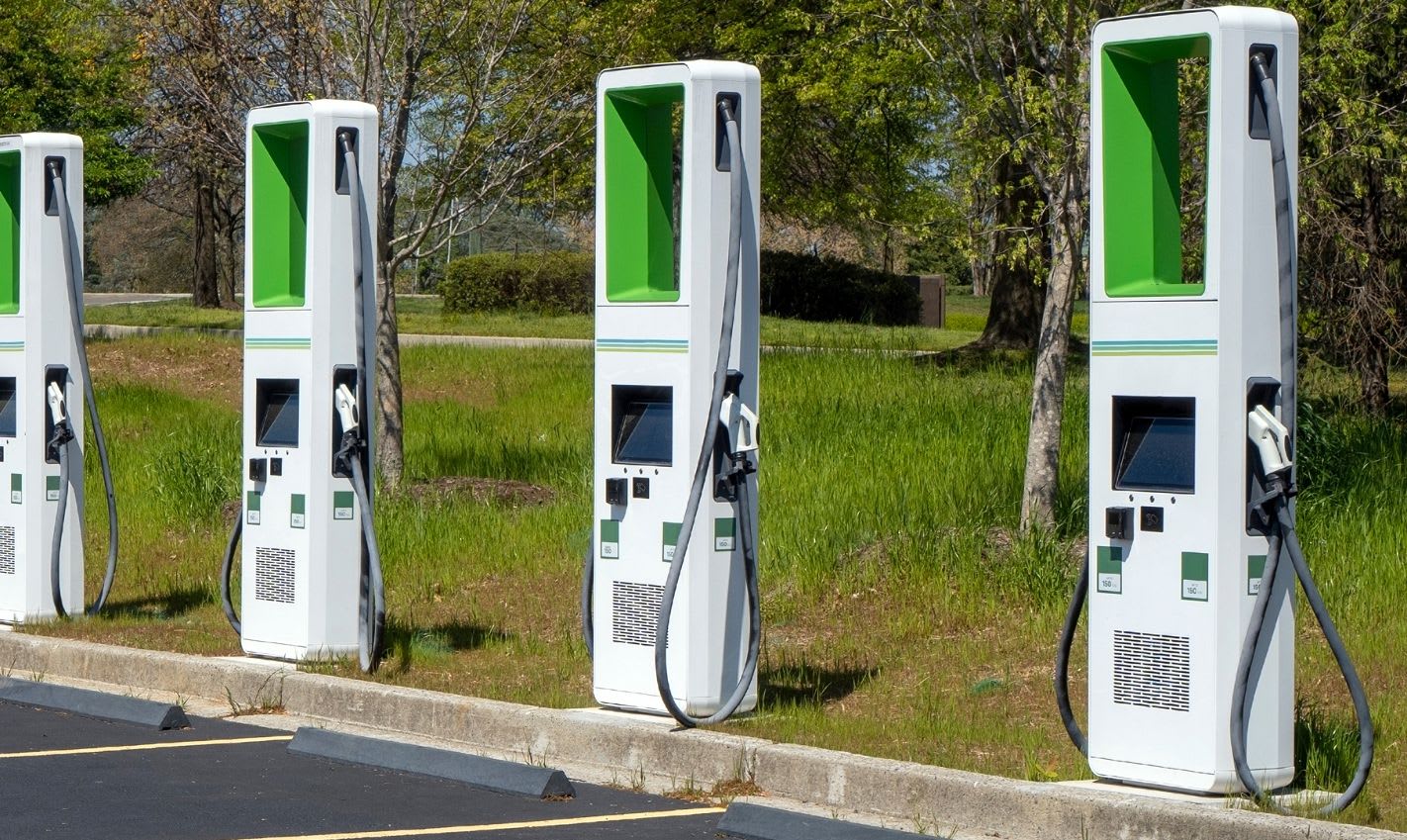 Electric vehicle charging stations in a parking lot at night.