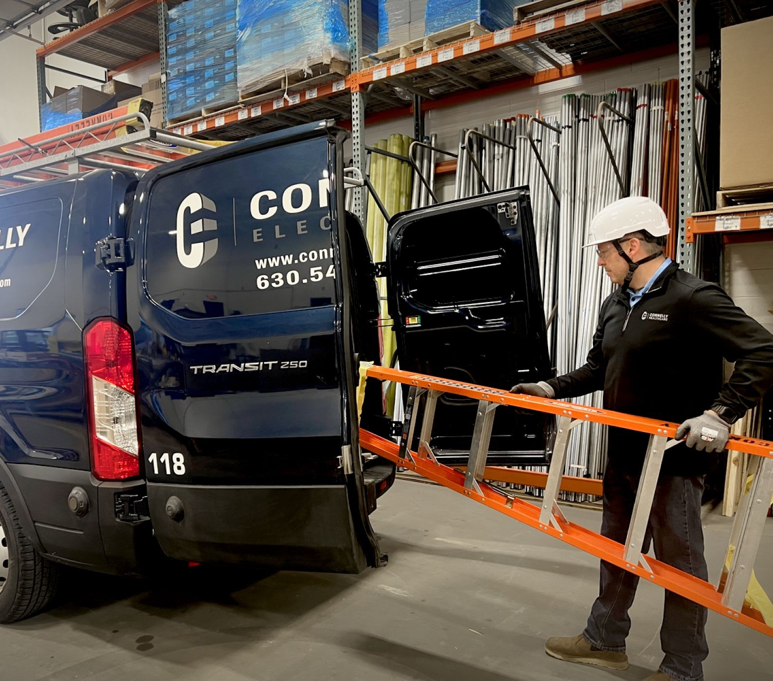 A Connelly Electric Maintenance technician loading a ladder into the service van.