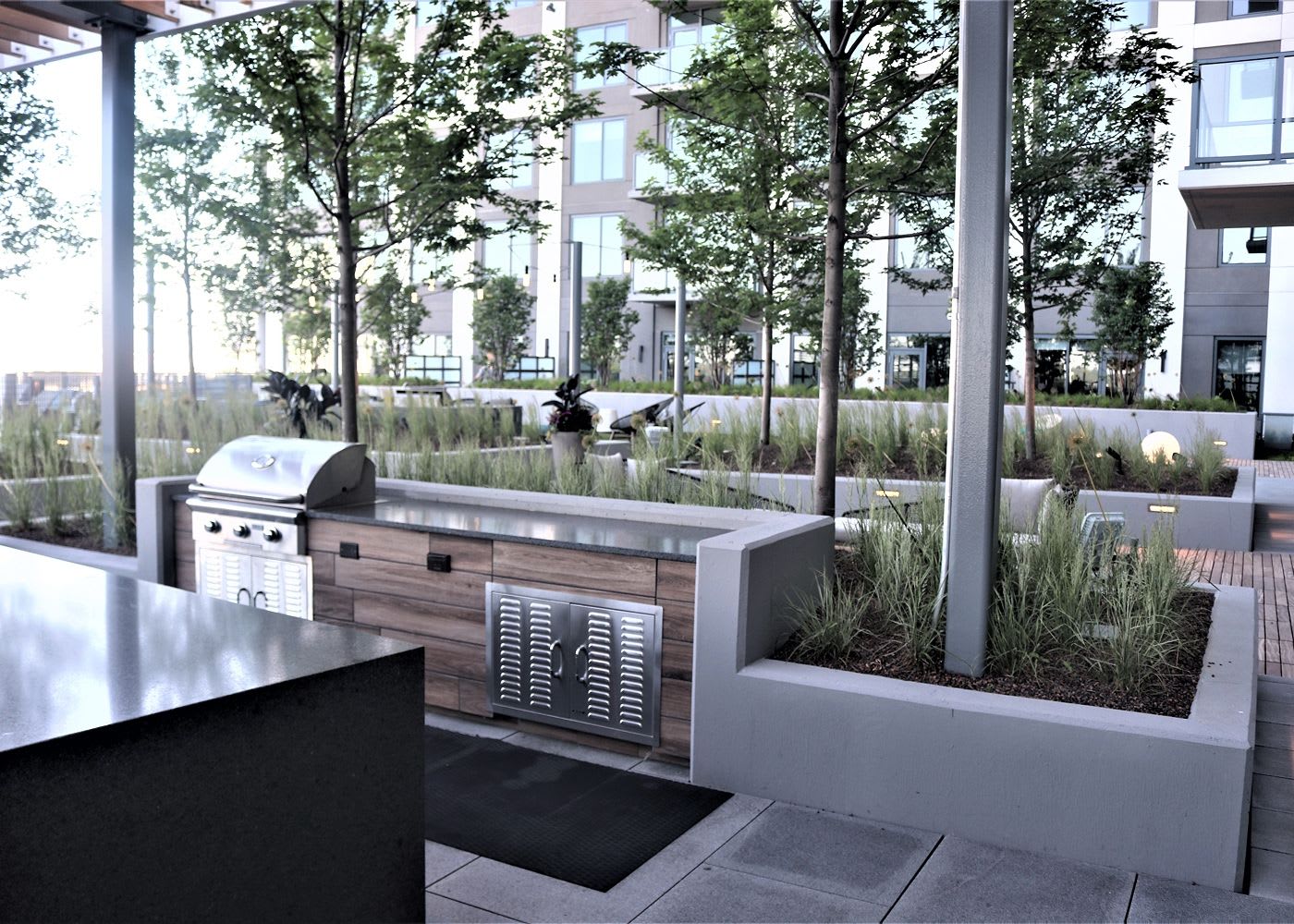 Outdoor grill area with outdoor lighting and greenery.