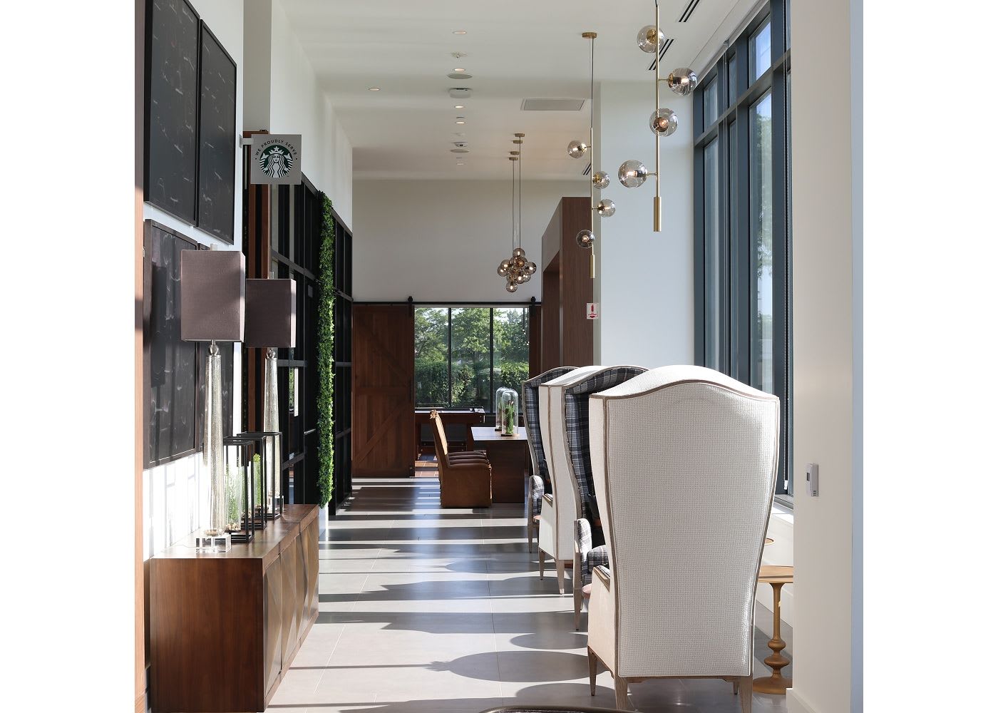 Long hallway with couches and modern light fixtures and furniture.
