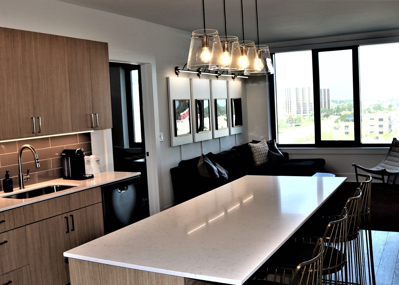 Residential space featuring a sink, large countertop and a comfortable living room space.