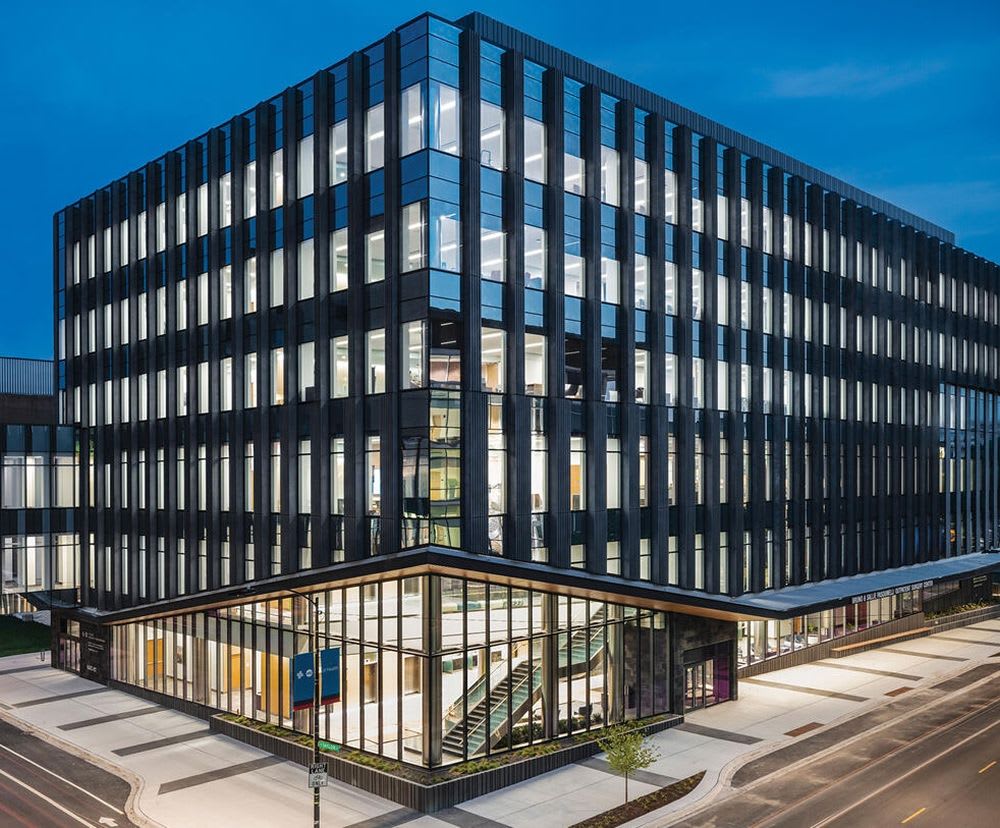 Outside view of the UI Health building at nighttime showing the entrance and windows illuminated.