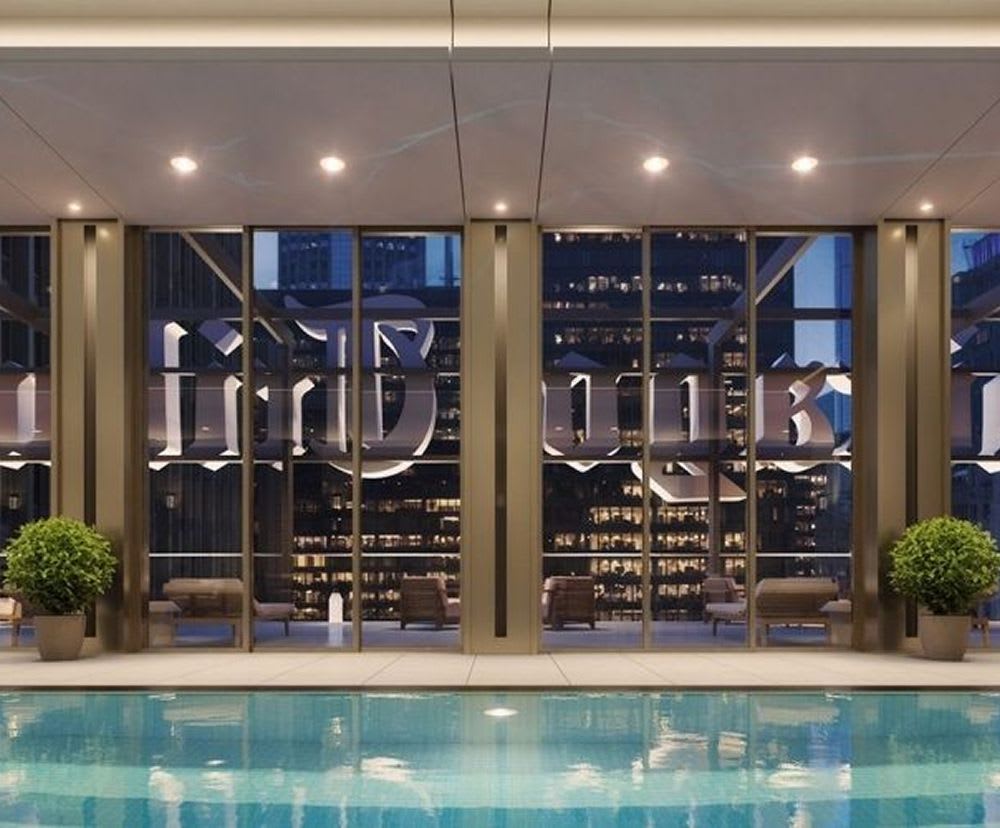 The swimming pool at the Tribune Tower with lighting illuminating it at night.