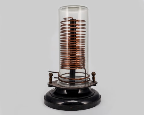Copper coil wrapped around a pole and protected by a glass cover.