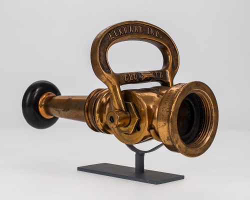 A brass fire hose nozzle with a black rubber tip from Elkhart Brass Manufacturing Company