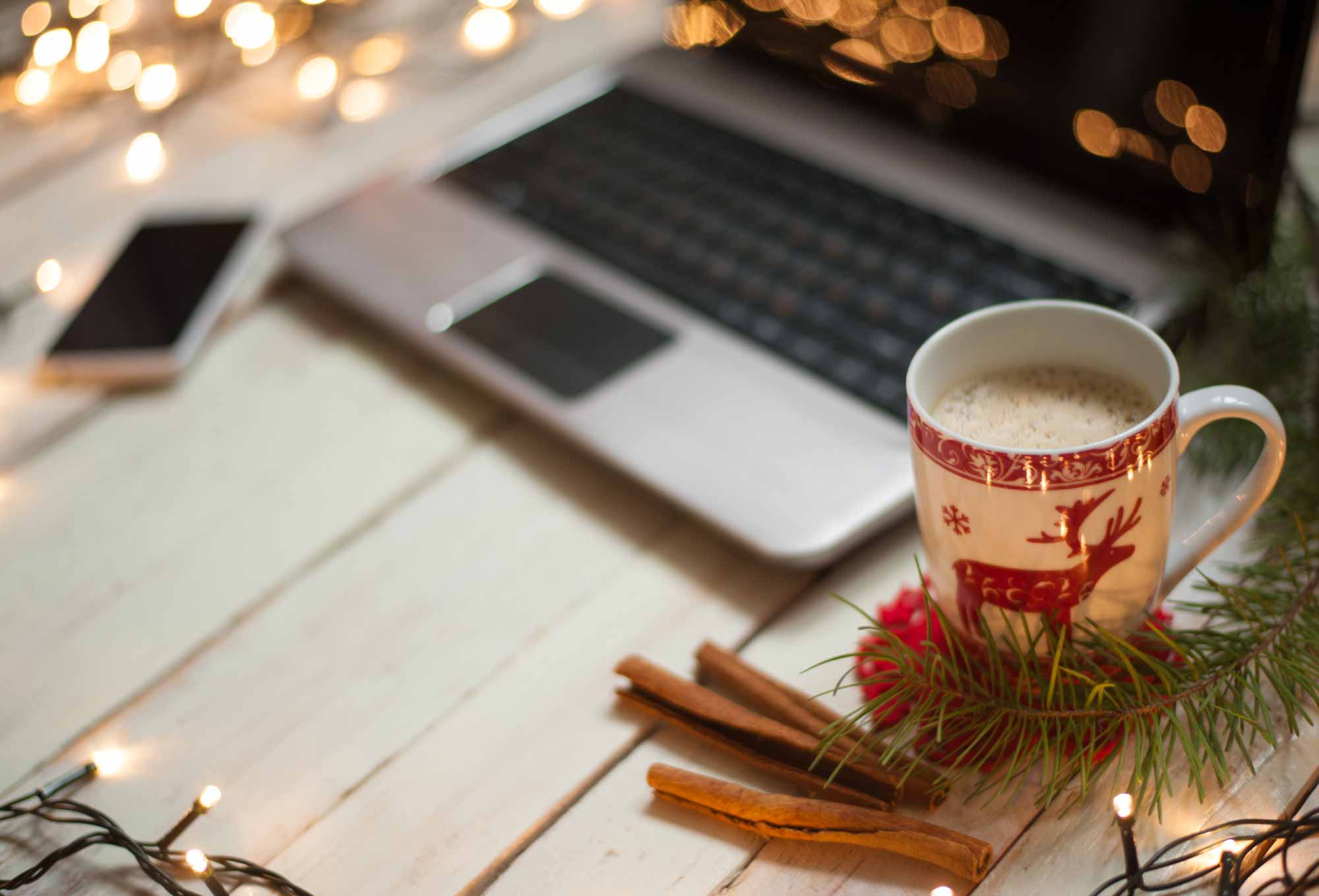 A holiday mug next to a laptop. | 5 Ways Task Automation Can Fill in for Employees During the Holidays | Impact