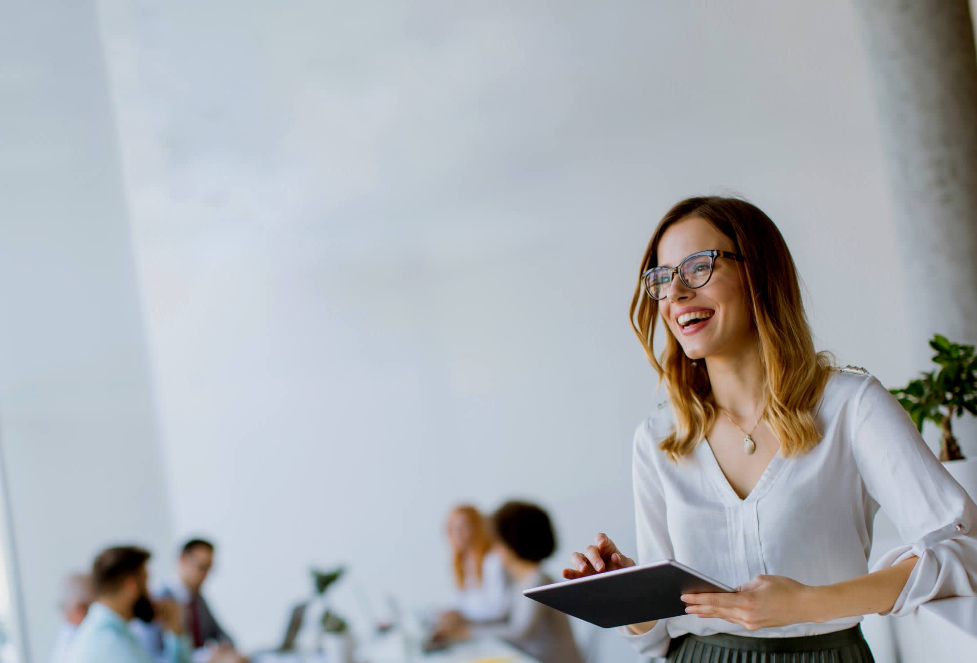 smiling woman with ipad in office