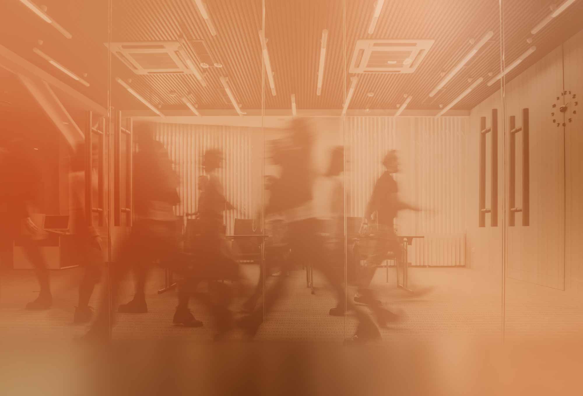 Orange-tinted image of people working in an office | talent shortage