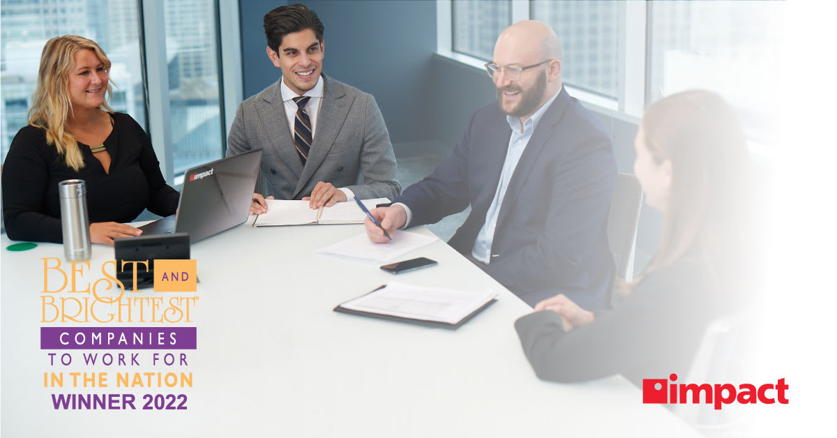 Four business professionals seated at conference table and collaborating