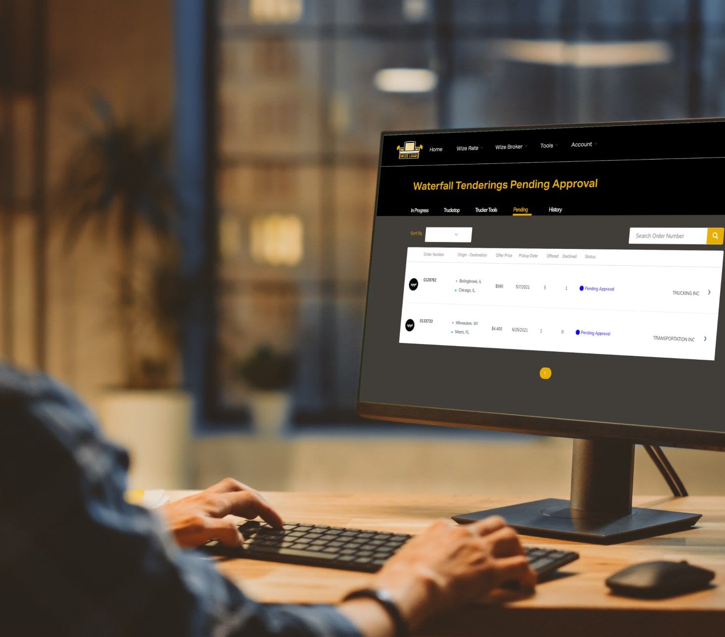 Wize Load customer sitting at desktop using the Wise Broker software to see historical data of projects.