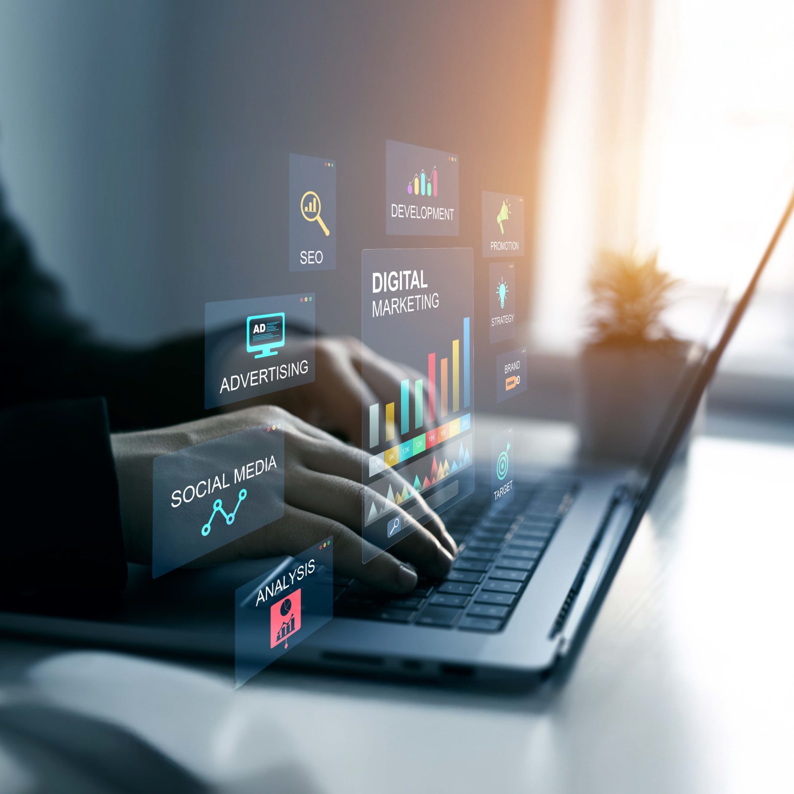 Two hands typing on a laptop with floating images above that indicate different marketing disciplines like social media, advertising, analysis, and digital marketing.